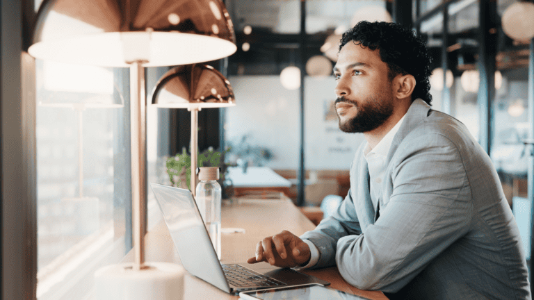 Man working on laptop at a cafe, raising awareness about anemia.